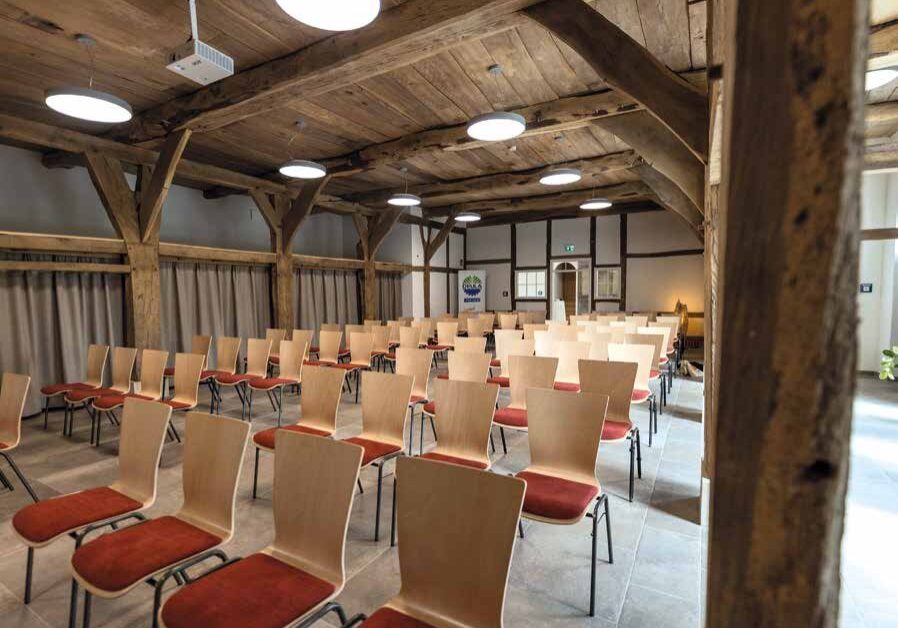 Bestuhlter Tagungsraum unter historischem Fachwerk